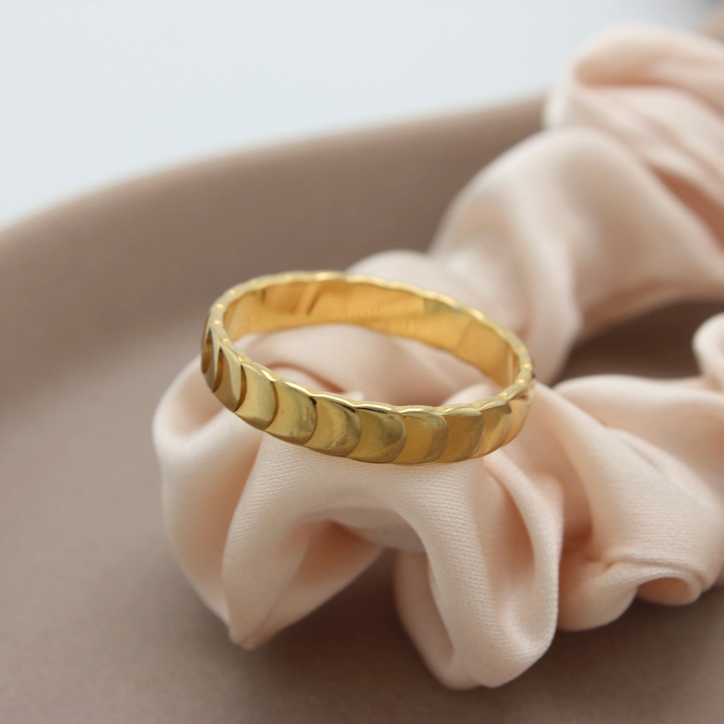 Gouden ring Dana met schubben op een stuk stof