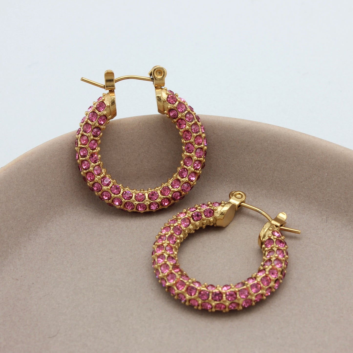 Gouden hoops met roze zirkonia steentjes vanuit de zijkant