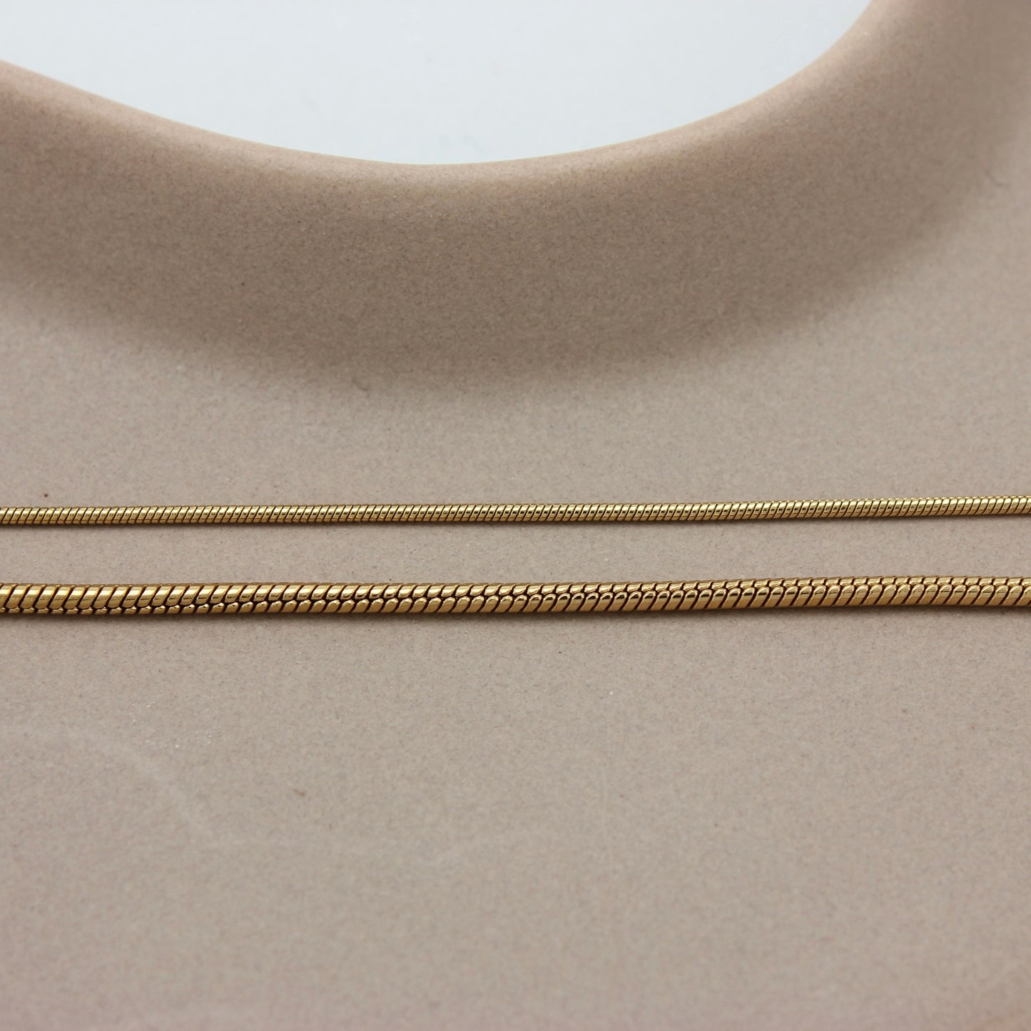 Vergelijking diameter van twee gouden minimalistische armbanden met een fijne schakel