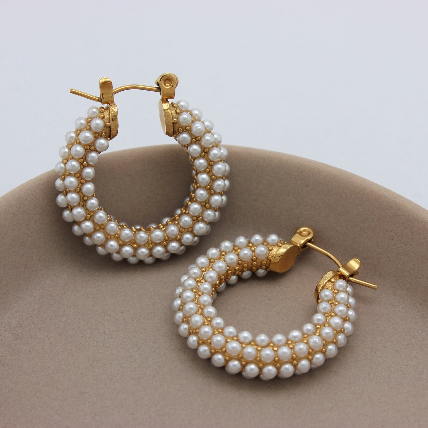 Een zijaanzicht van gouden oorbellen met parels