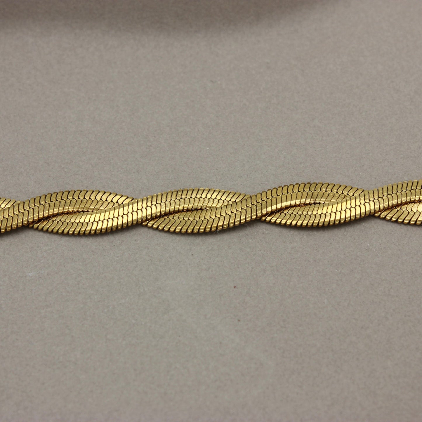 Detail van gevlochten platte gouden ketting