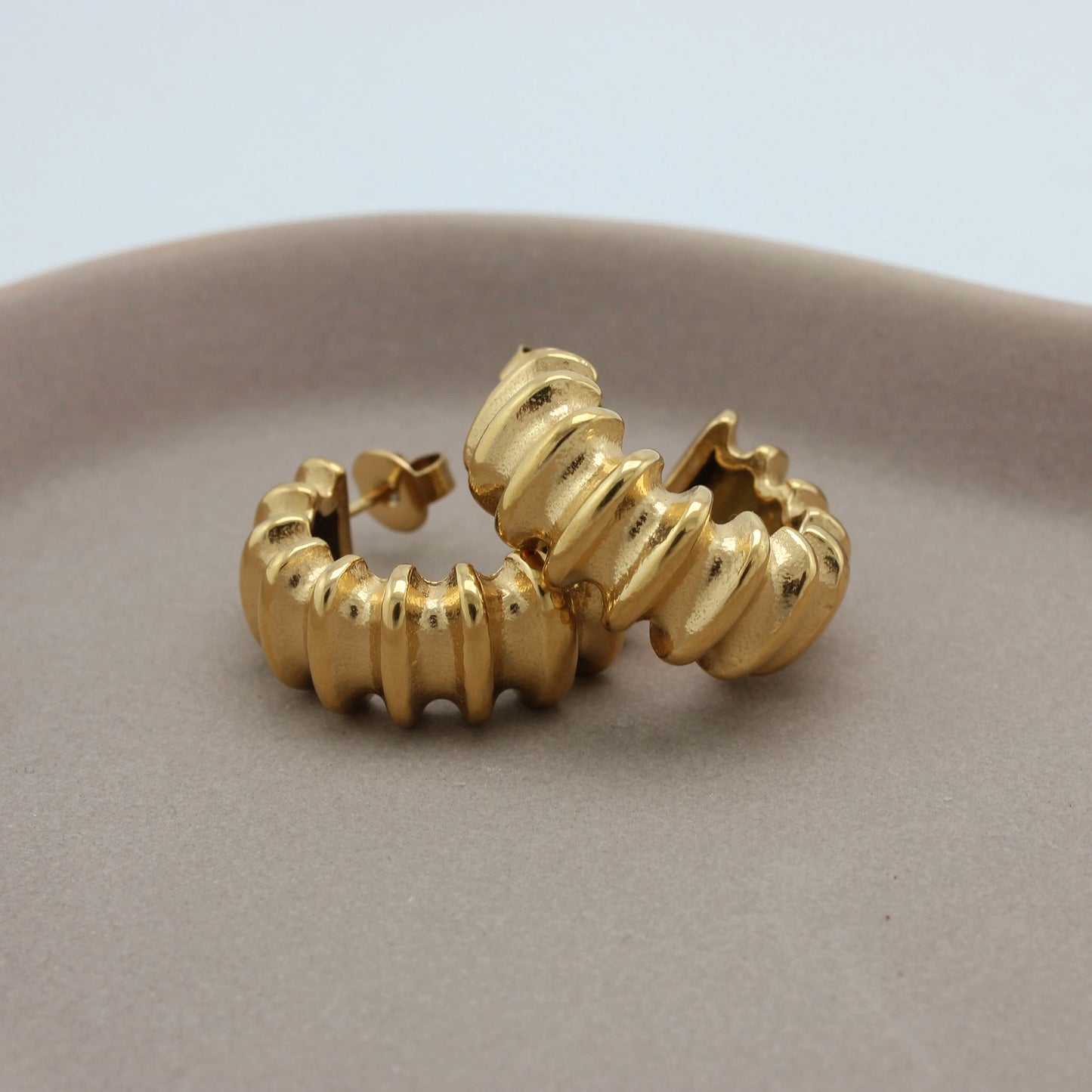 Gouden creolen liggend op elkaar