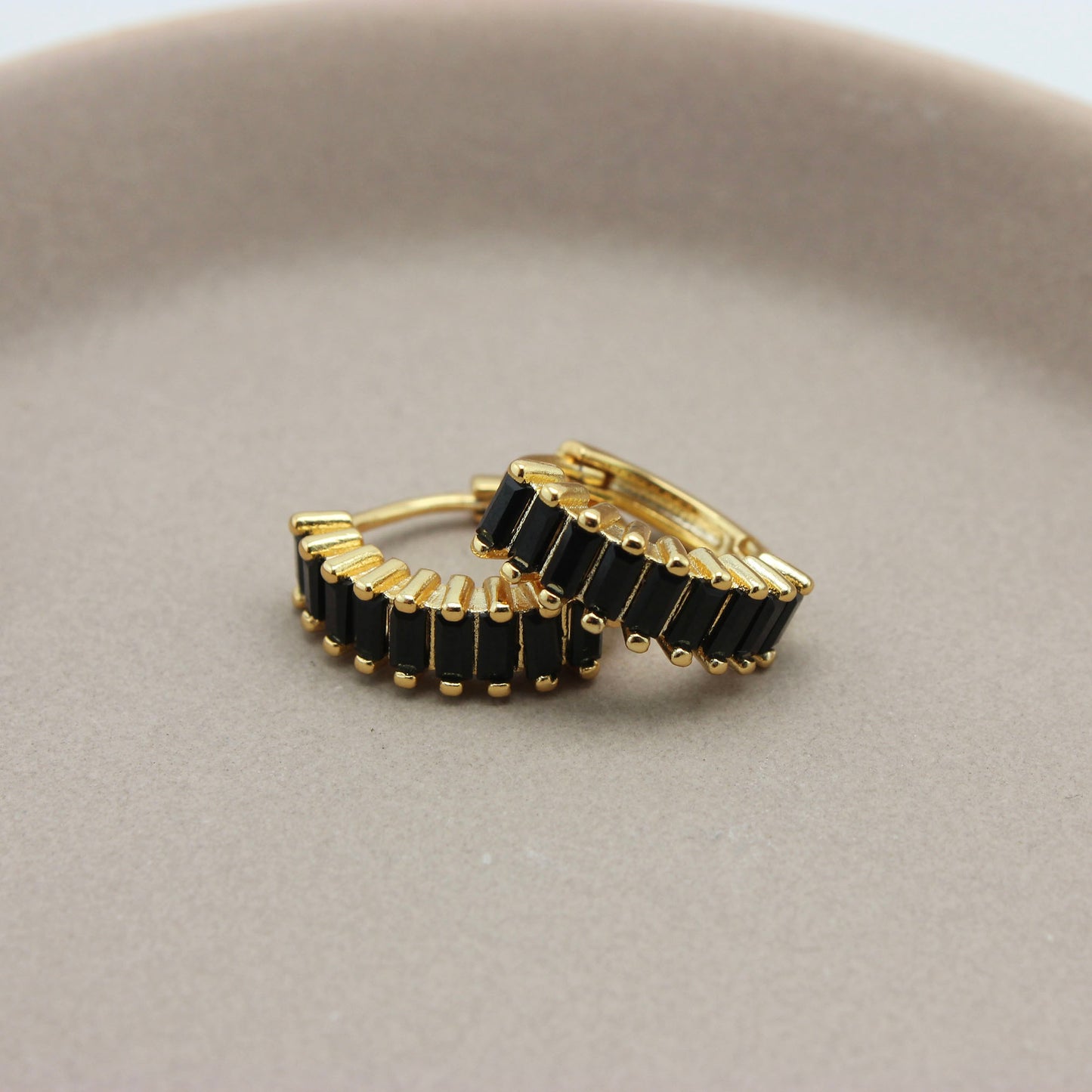 Gouden hoops met zwarte zirkonia steentjes liggend