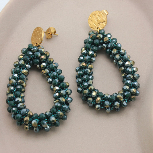 Gouden oorstekers met donkergroene kralen vanuit een zijaanzicht