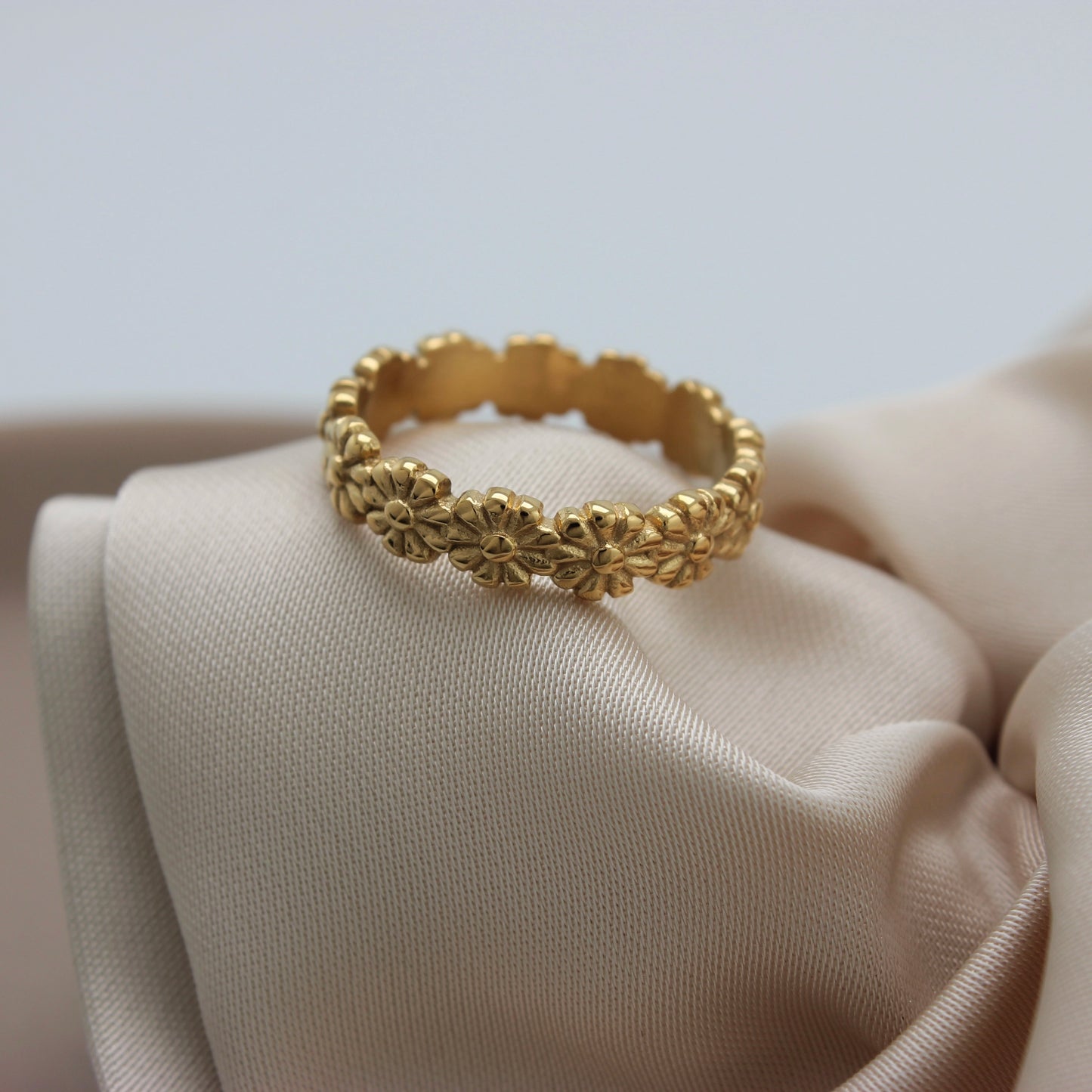 Bloemige gouden ring op een stofje