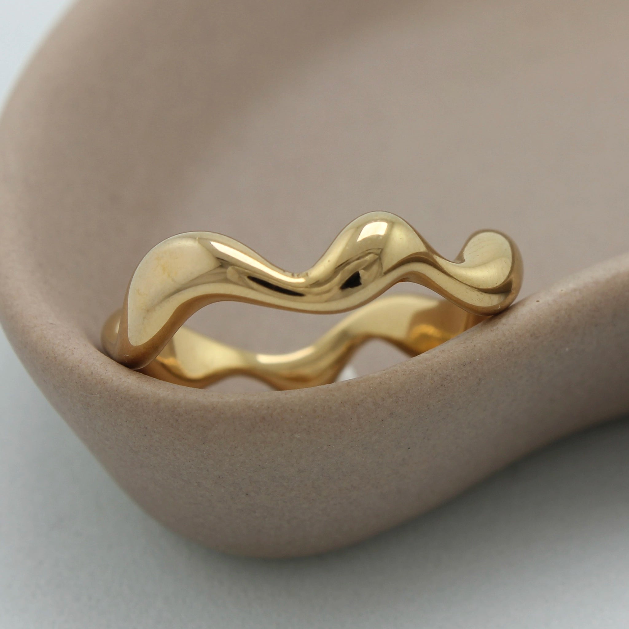 Zijaanzicht van een gouden asymmetrische ring