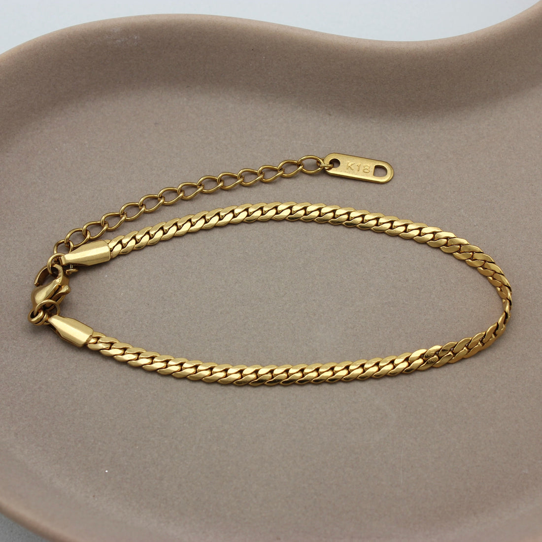 Gouden schakel armband op een schaaltje