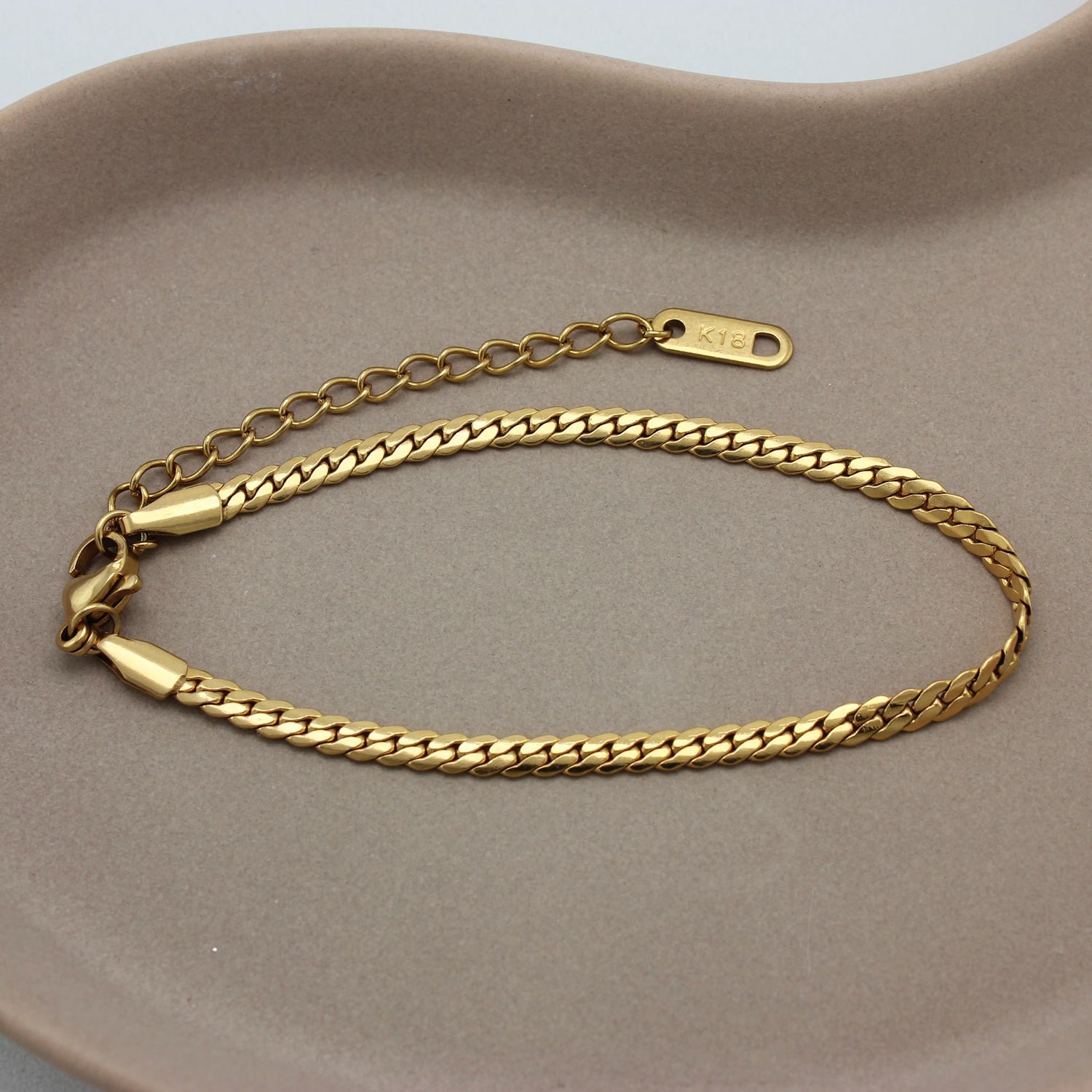 Gouden schakel armband op een schaaltje