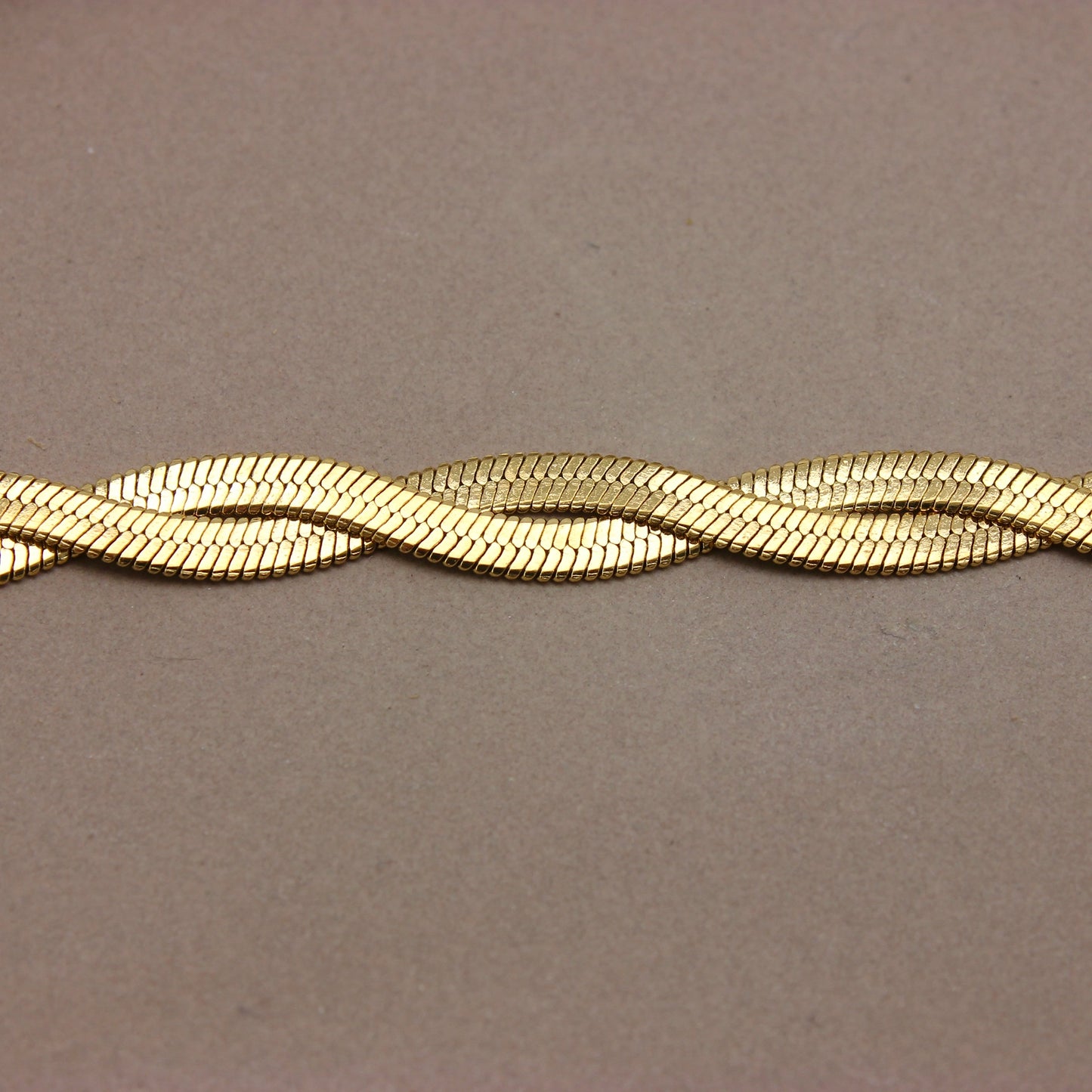 Gouden platte gevlochten armband detail