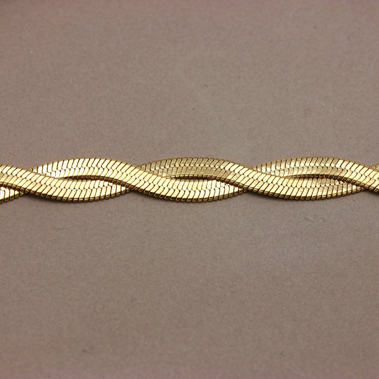 Gouden platte gevlochten armband detail
