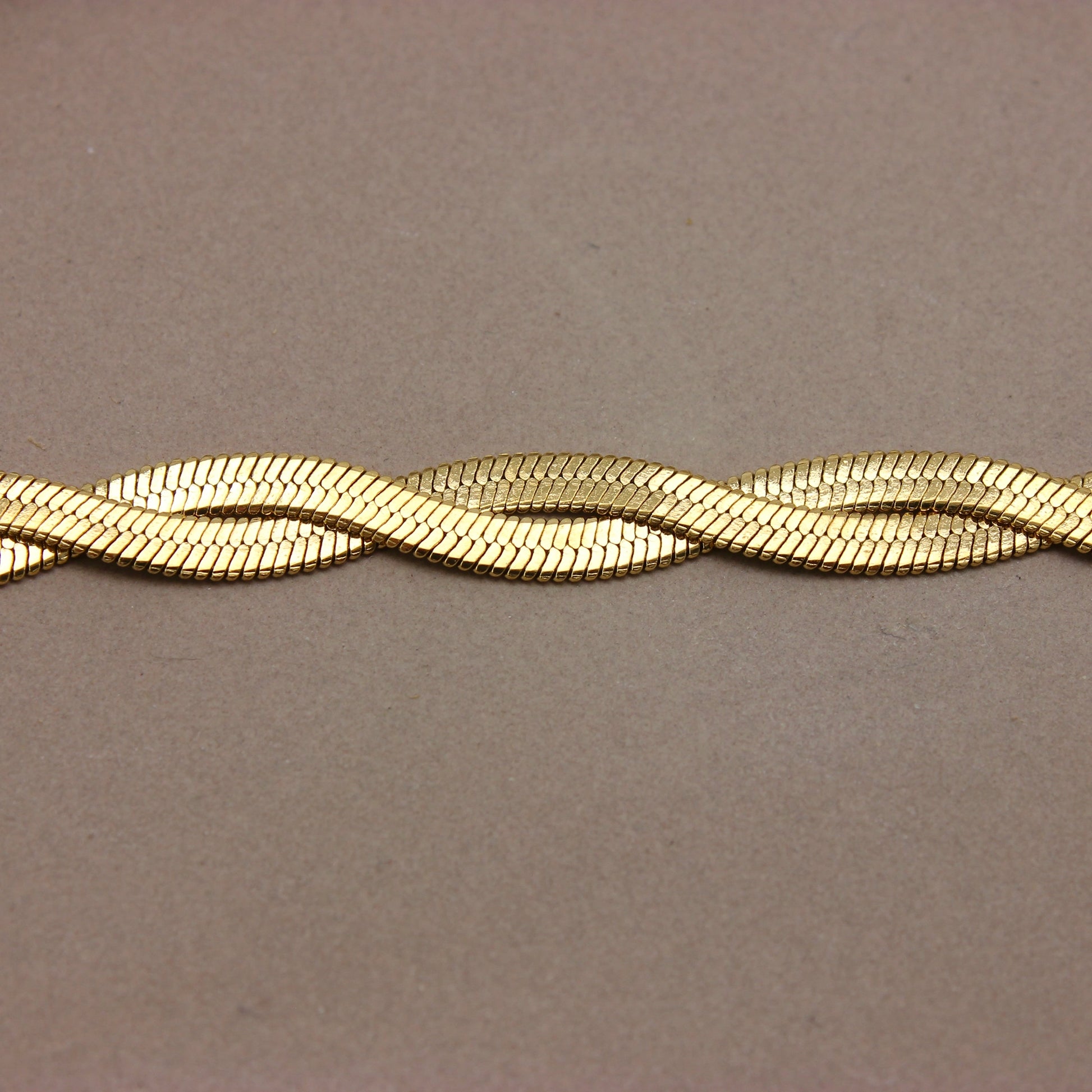 Gouden platte gevlochten armband detail