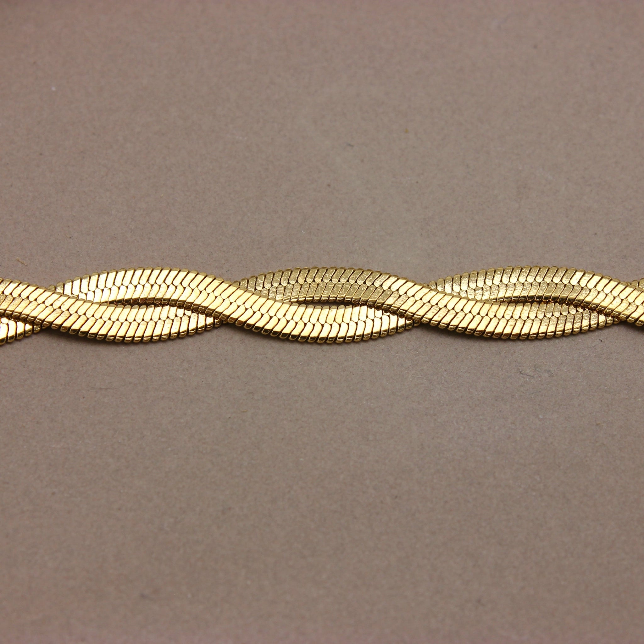 Gouden platte gevlochten armband detail
