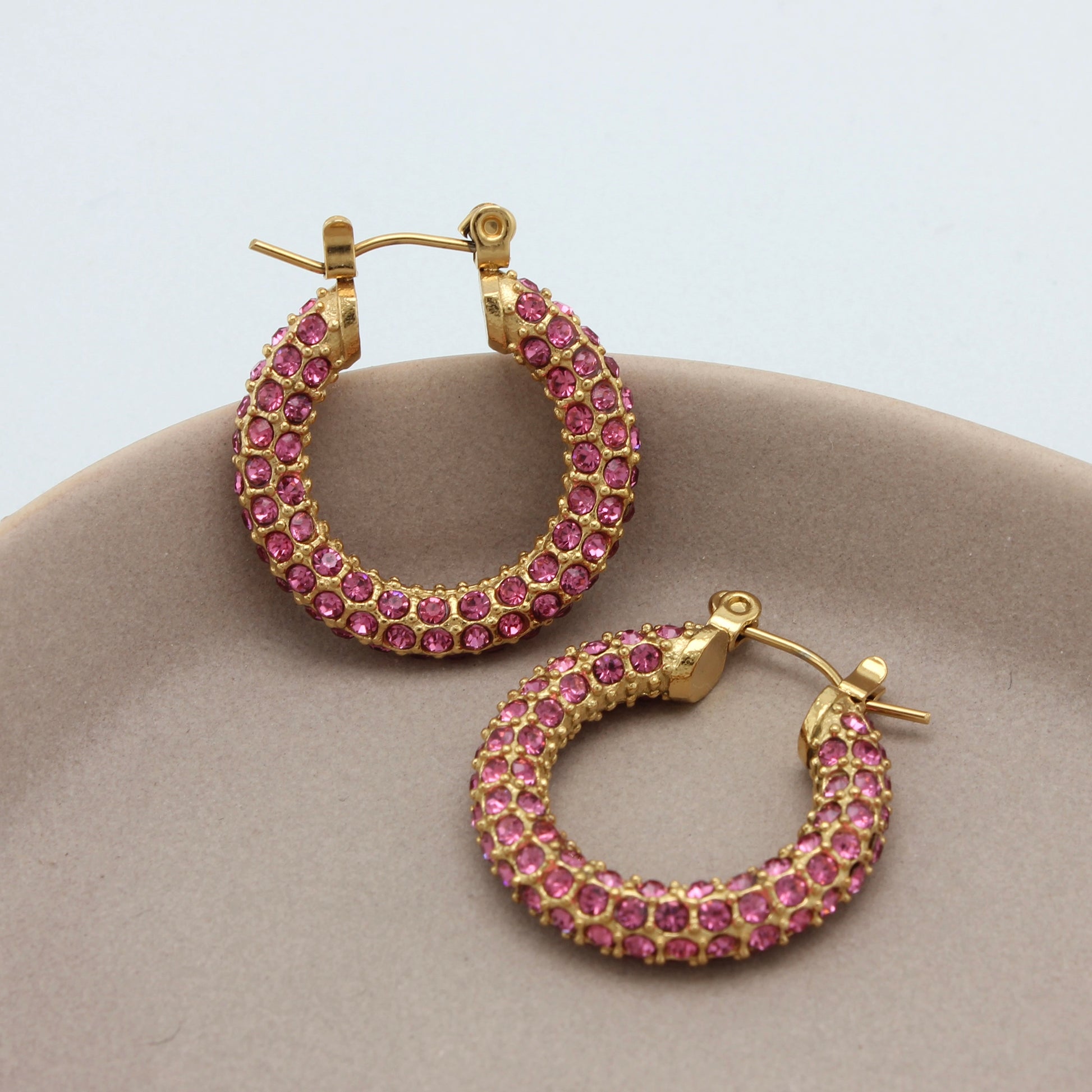 Gouden hoops met roze zirkonia steentjes vanuit de zijkant