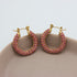 Gouden hoops met roze zirkonia steentjes op een schaaltje