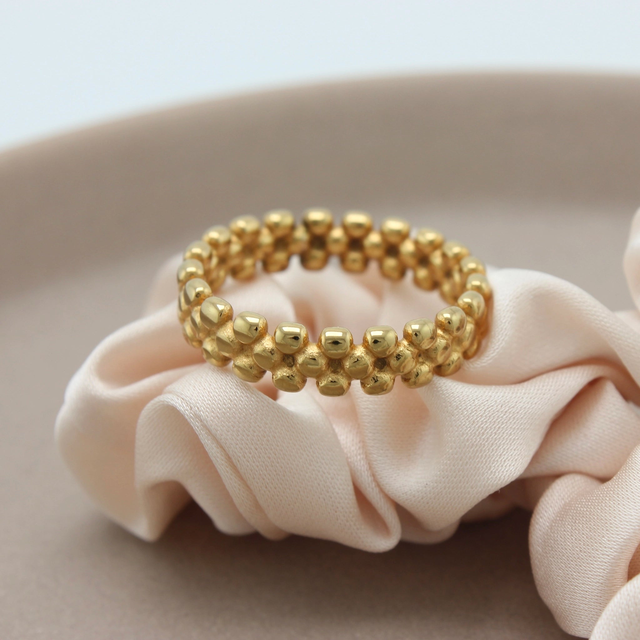 Gouden ring op een beige stofje