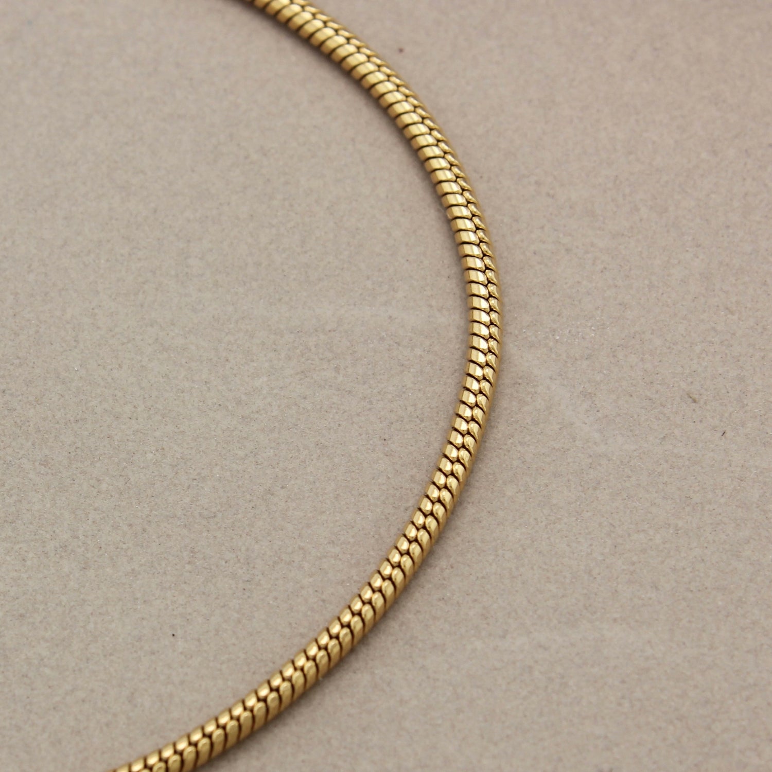 Gedetailleerde foto van de fijne schakels van een gouden minimalistische armband