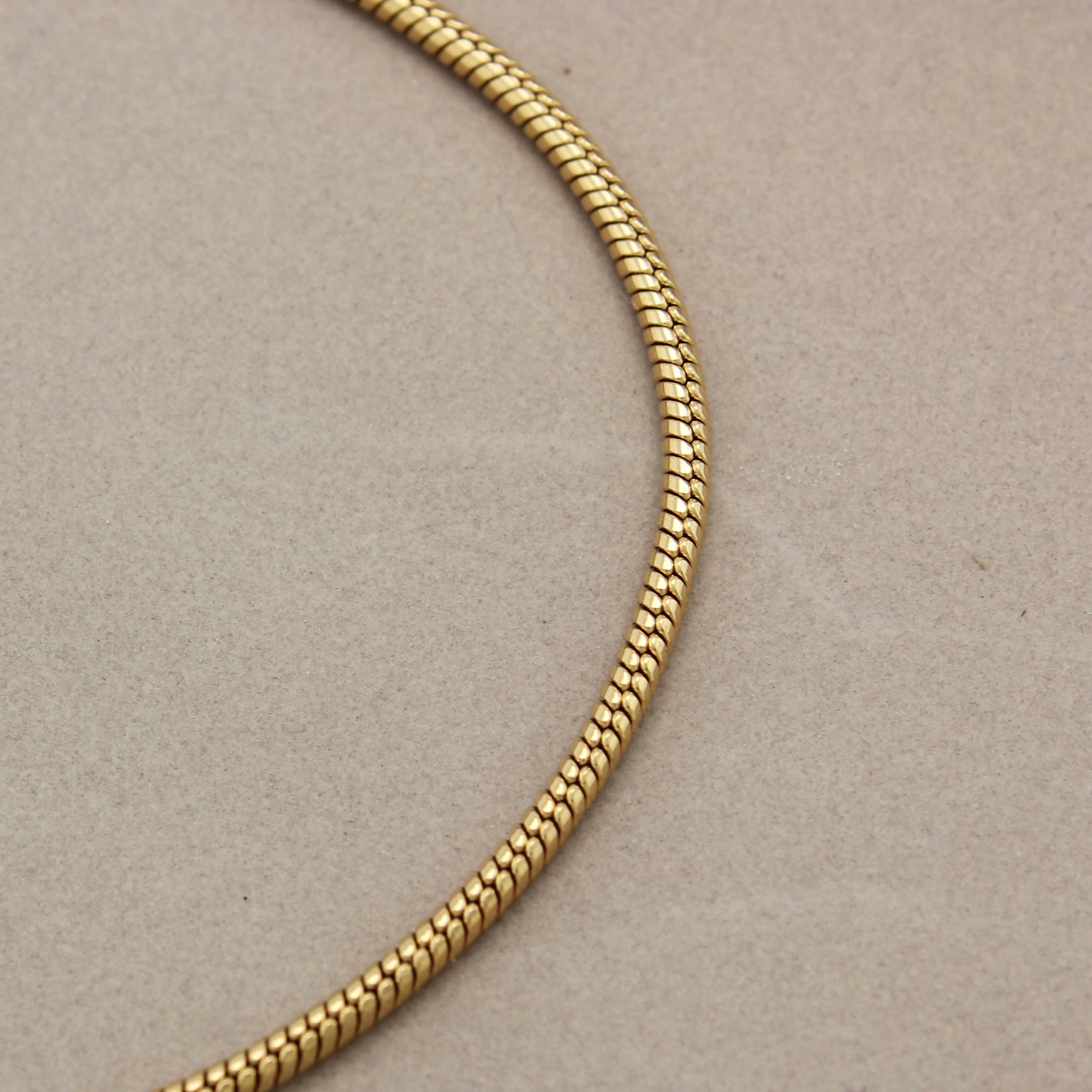 Gedetailleerde foto van de fijne schakels van een gouden minimalistische armband