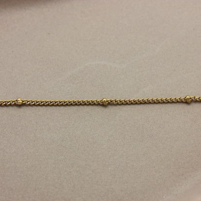 Gedetailleerde foto van de schakels en de bolletjes van de gouden ketting