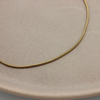 Gedetailleerde foto met de fijne schakels van een gouden minimalistische armband