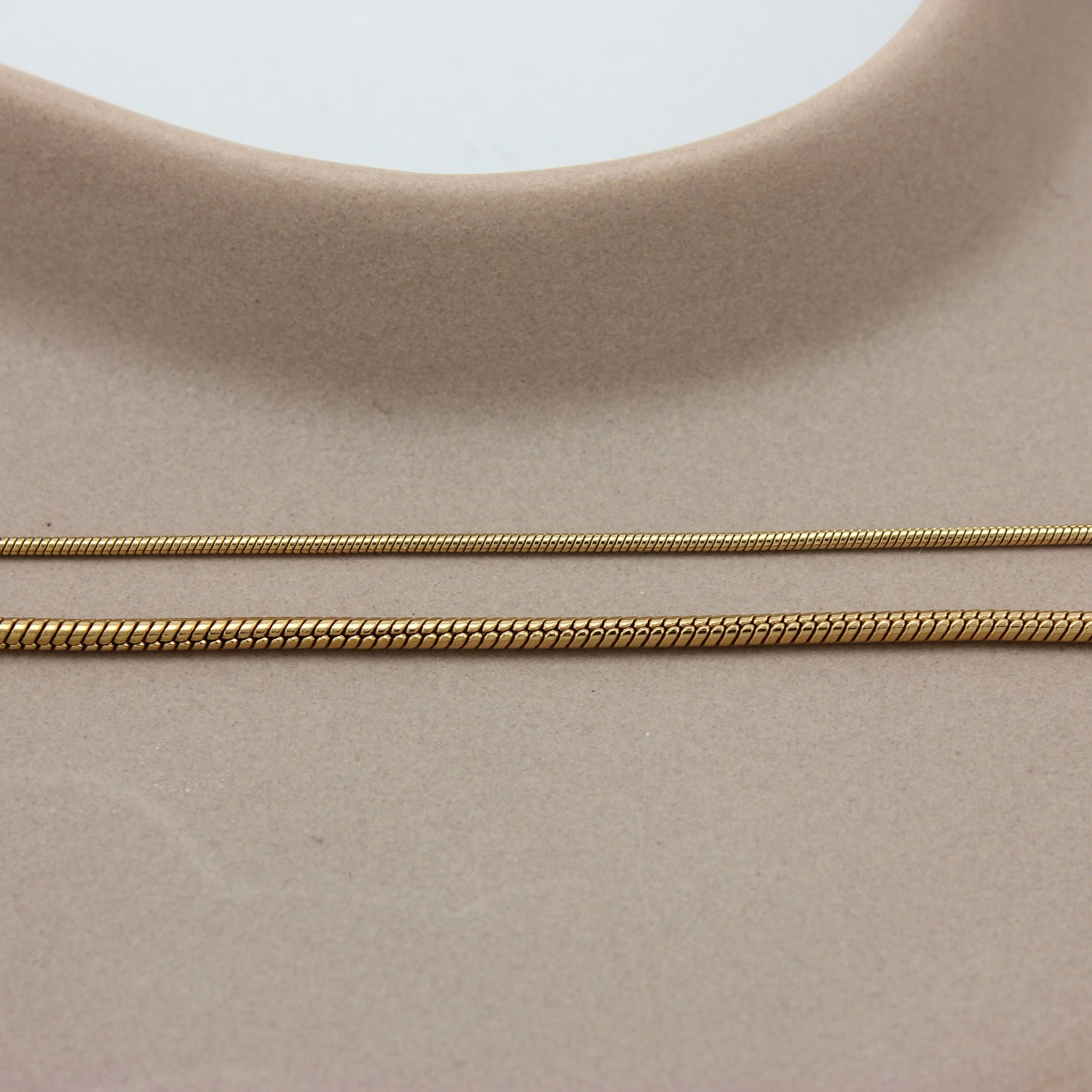 Vergelijking diameter van twee gouden minimalistische armbanden met een fijne schakel