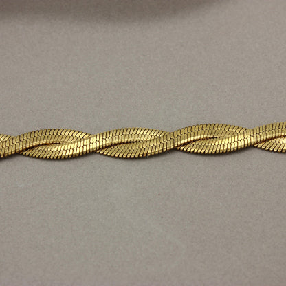 Detail van gevlochten platte gouden ketting