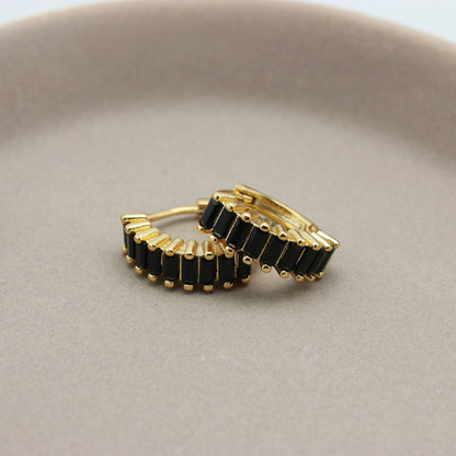 Gouden hoops met zwarte zirkonia steentjes liggend