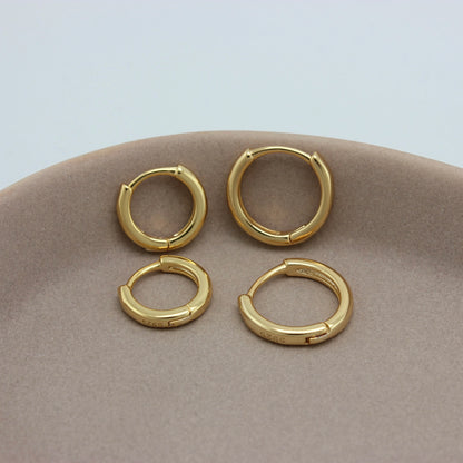 Kleine gouden hoops in twee formaten op een schaaltje