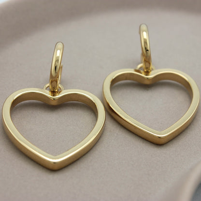 Gouden kleine hoops met hartjes hangers met gelijk lichtval