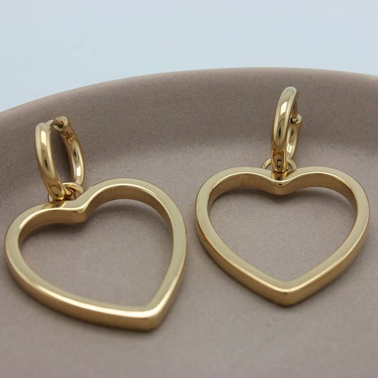 Gouden kleine hoops met hartjes hangers van een bovenaanzicht