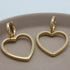 Gouden kleine hoops met hartjes hangers van een bovenaanzicht