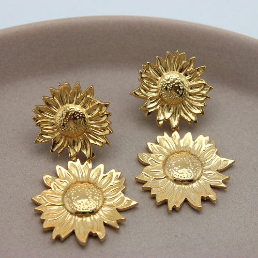 Gouden zoennebloem oorbellen naast elkaar