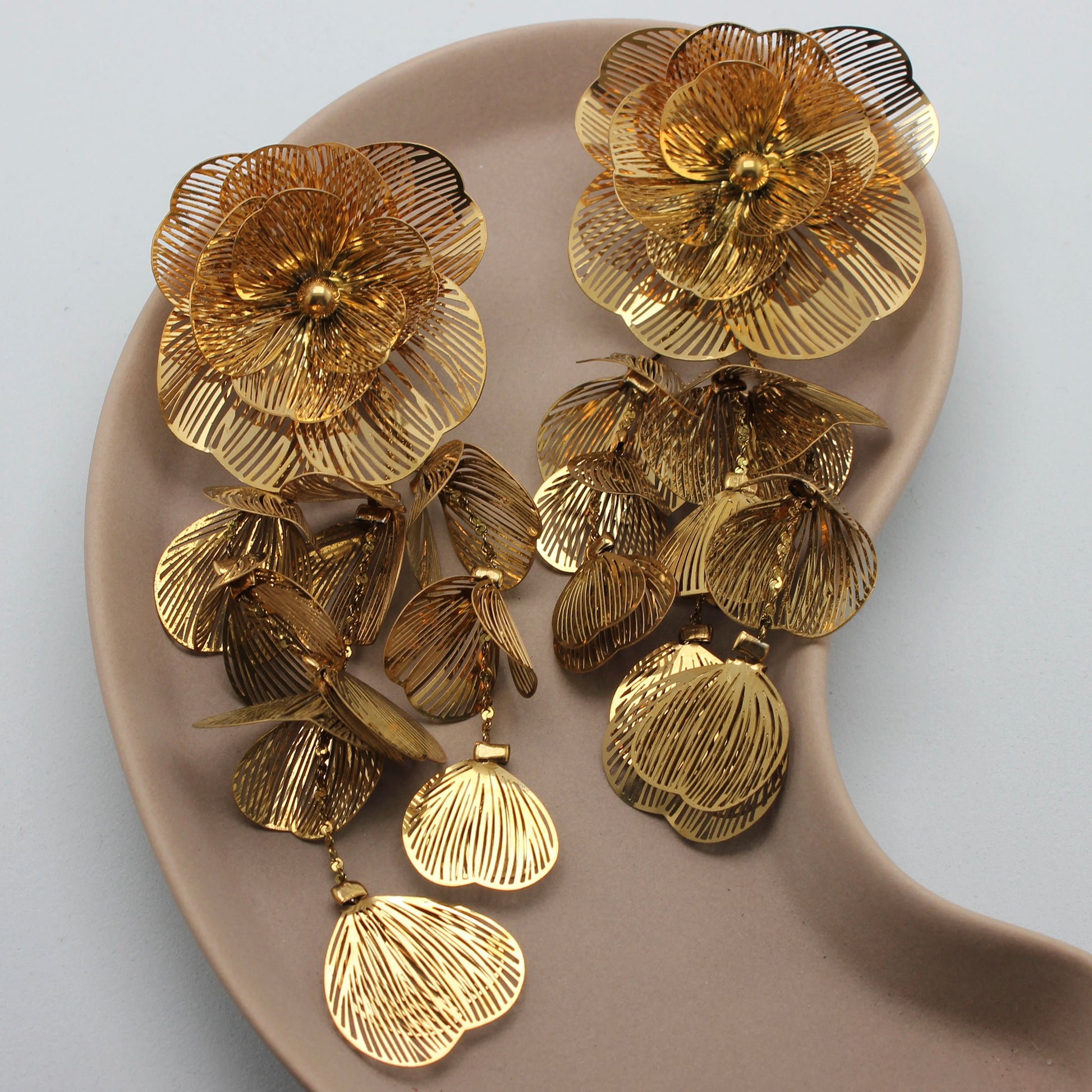 Feestelijke gouden oorbel met hangende bloemen en blaadjes vanuit een bovenaanzicht