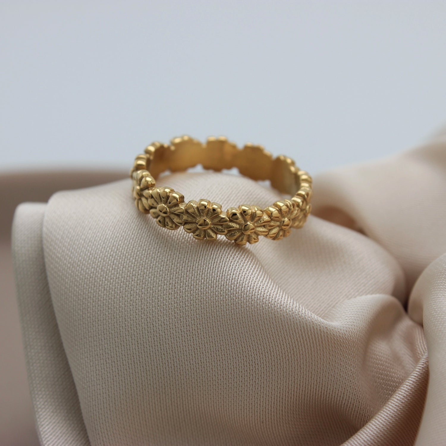 Bloemige gouden ring op een stofje