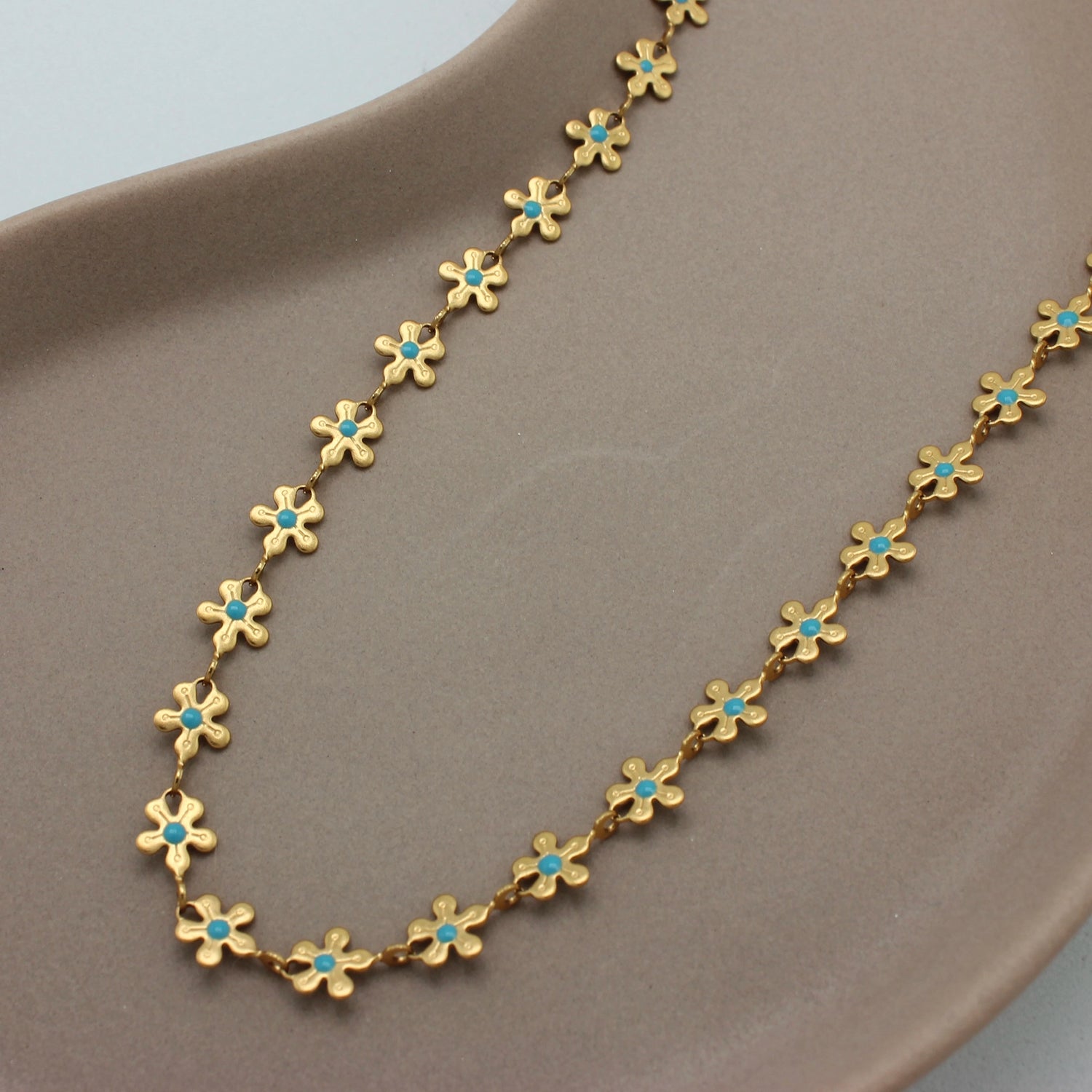 Gouden bloemen ketting met blauwe stip genaamd ketting Rosie